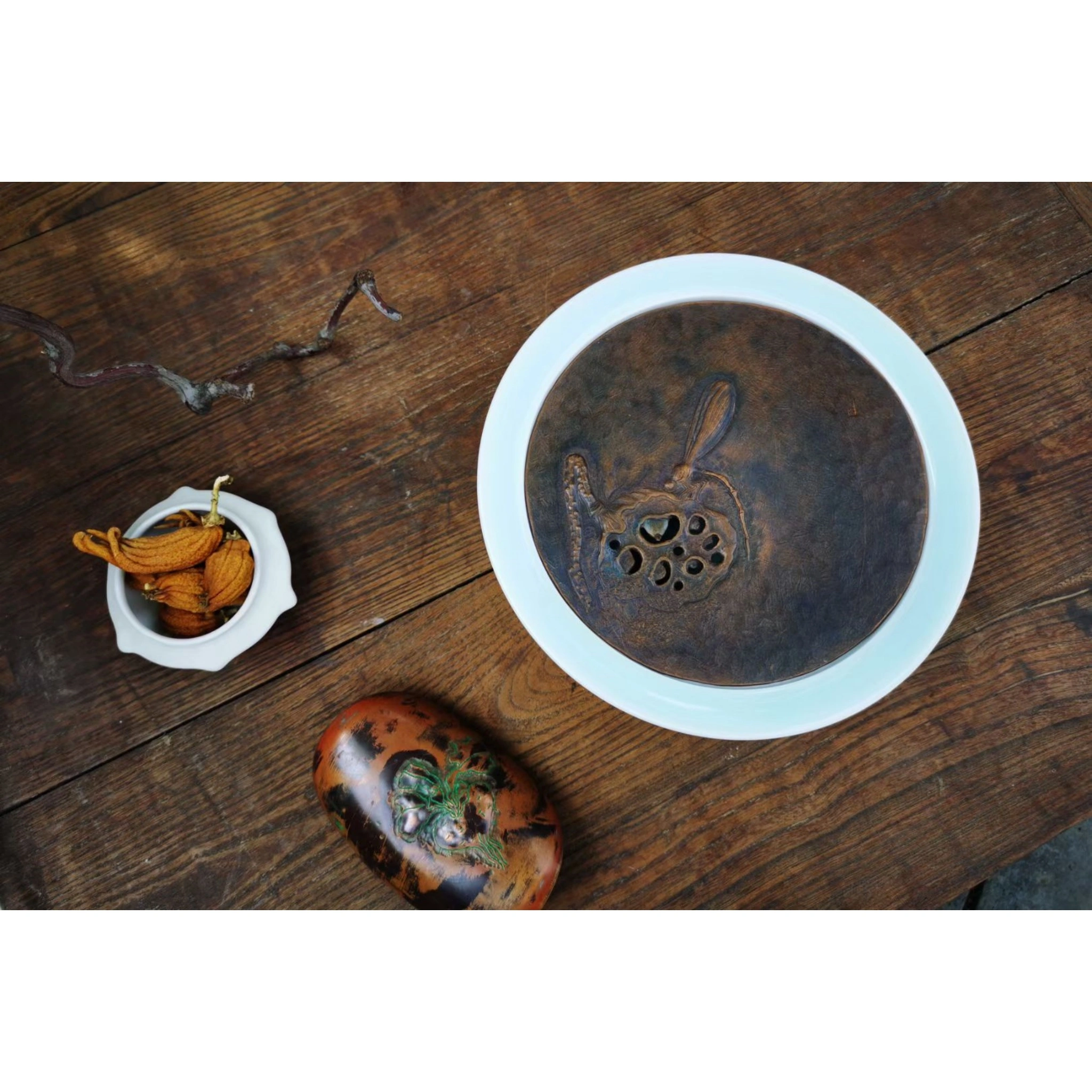 Ceramic and copper combination teacup saucer in use on traditional tea table with teacup, lifestyle scene showing mixed-material design,