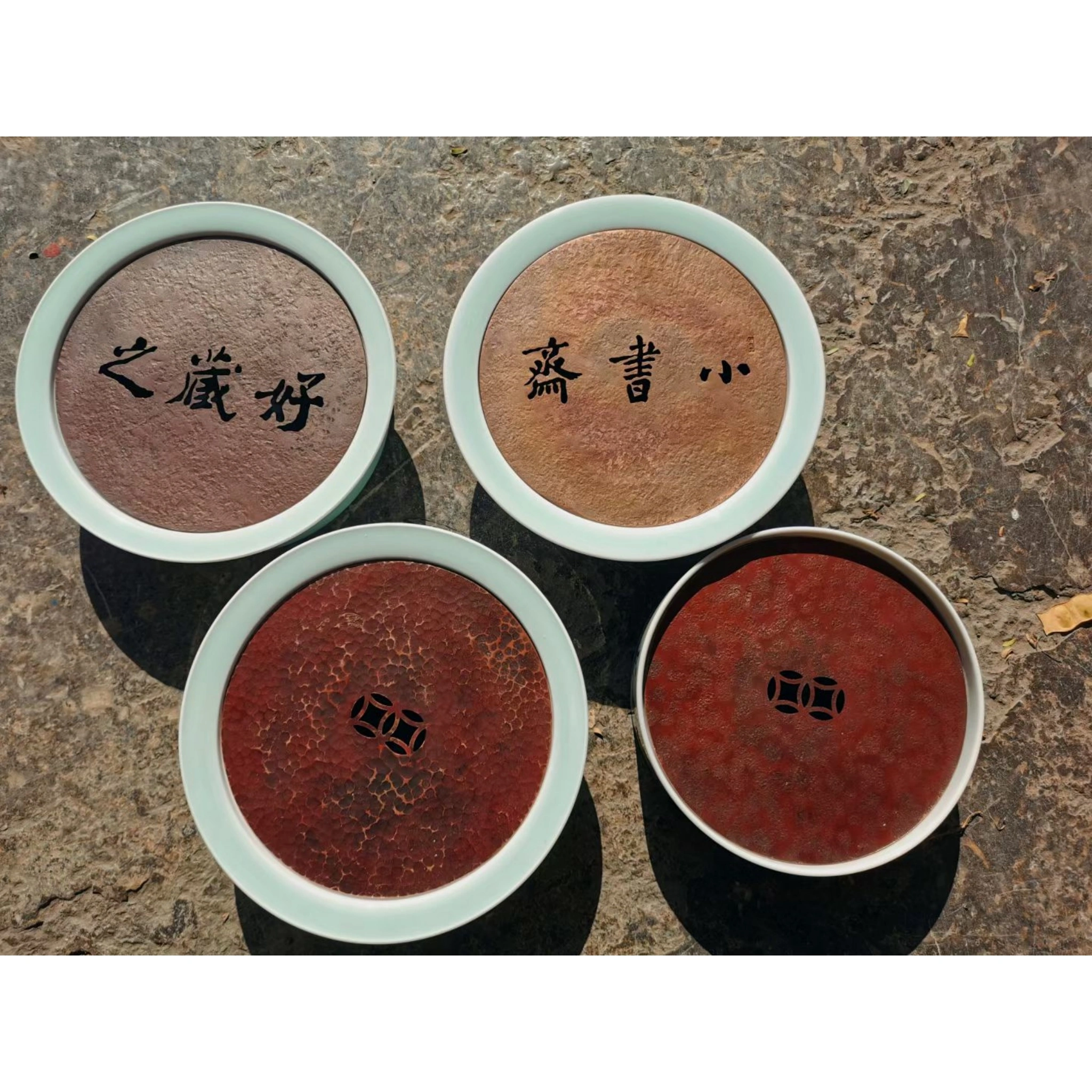 Collection of ceramic and hammered copper combination teacup saucers in multiple styles and patterns, showing variety of mixed-material designs,