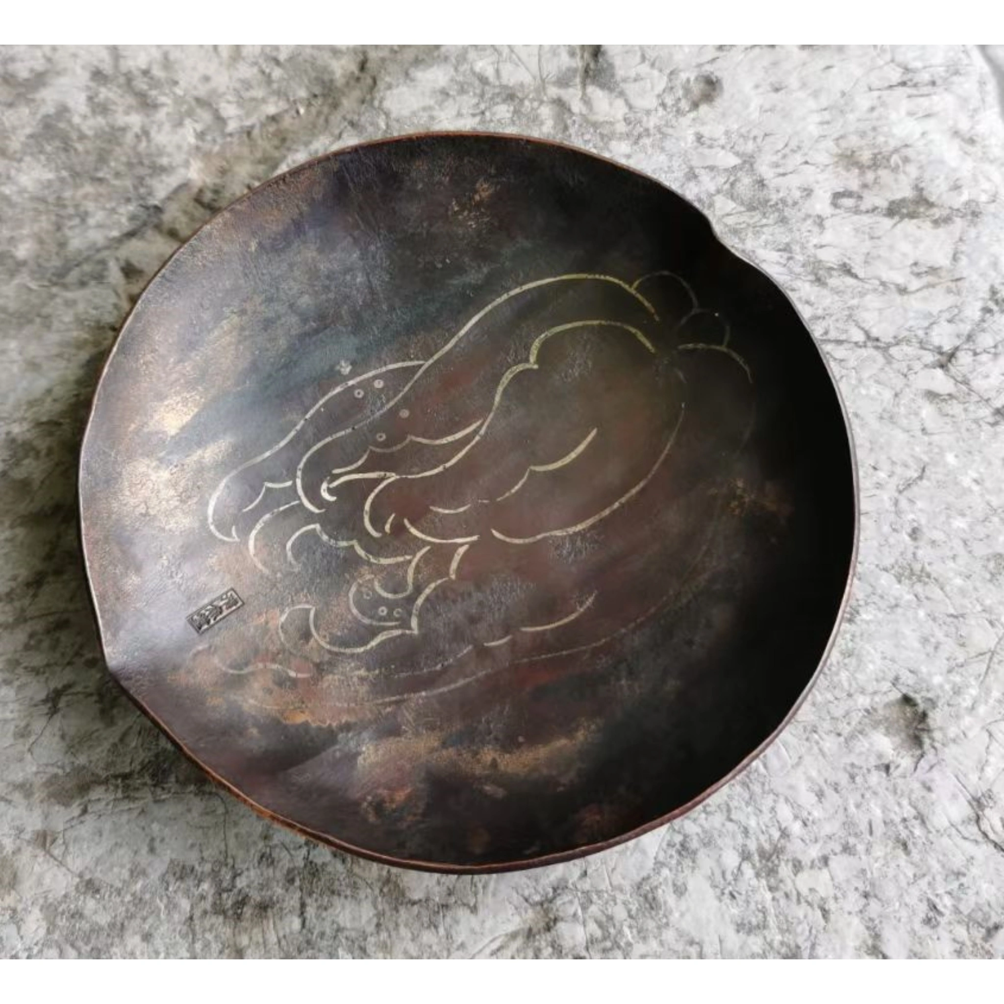 Close-up of hand-engraved floral motif on antique copper tea tray
