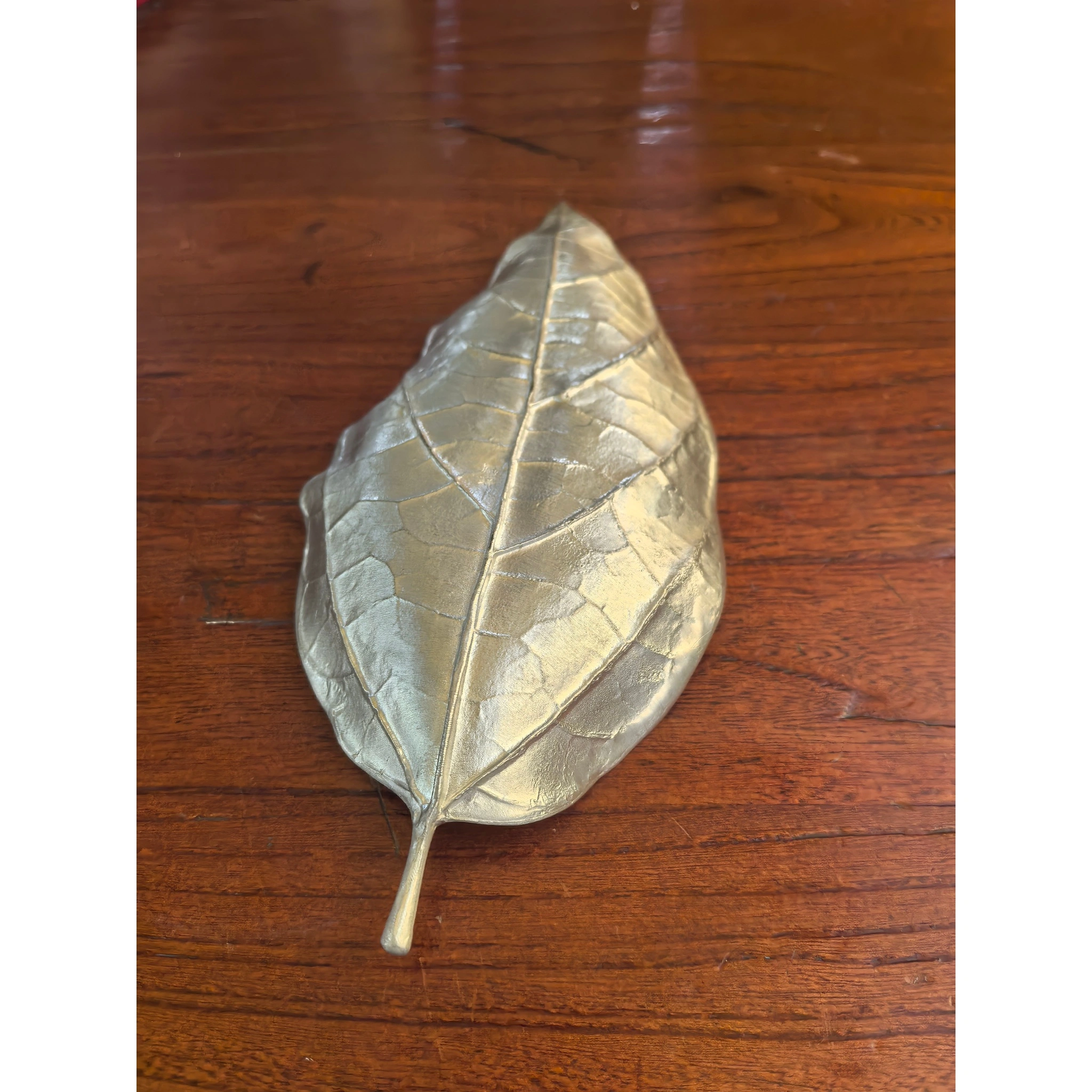 Hammered tin leaf-shaped tea scoop back view, showing smooth reverse side and metallic finish