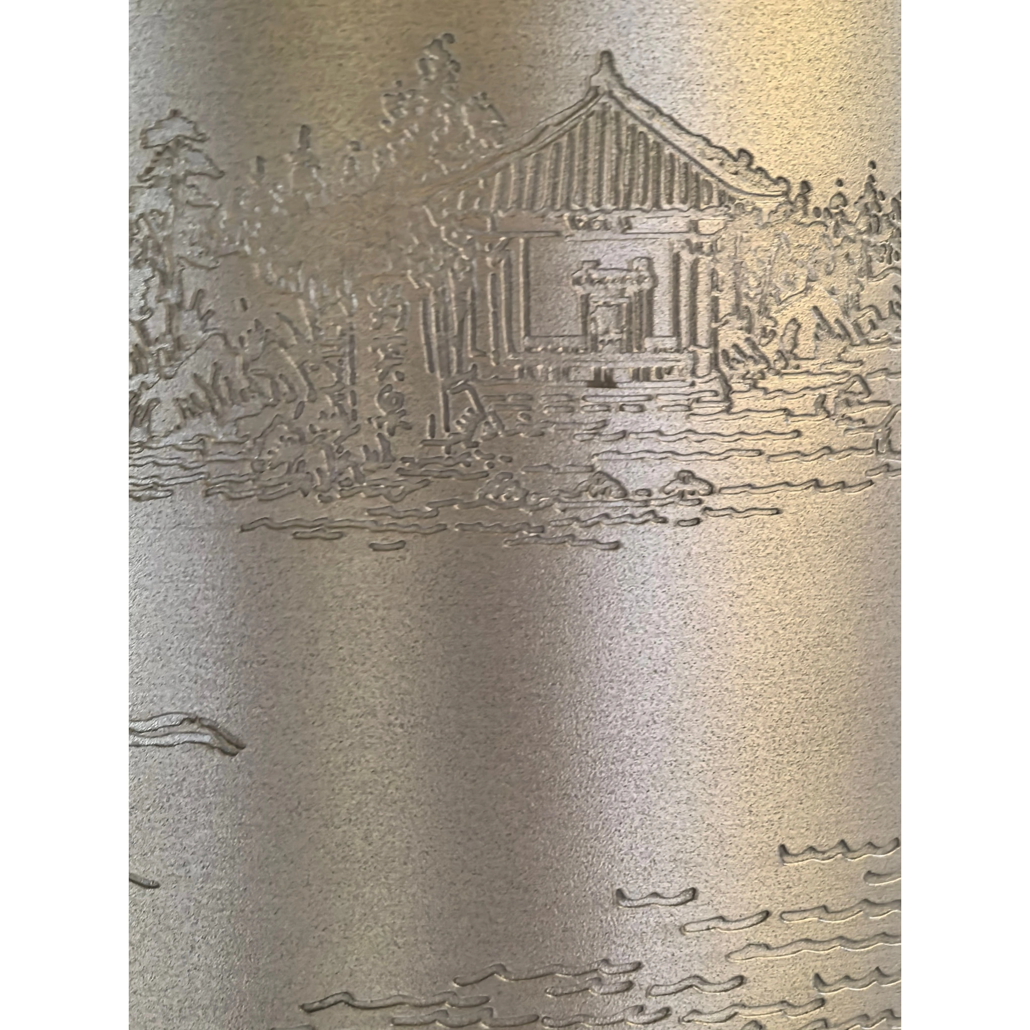 Close-up of hand-engraved Baotu Spring landscape on tin tea caddy, showing spring water and scenic details,
