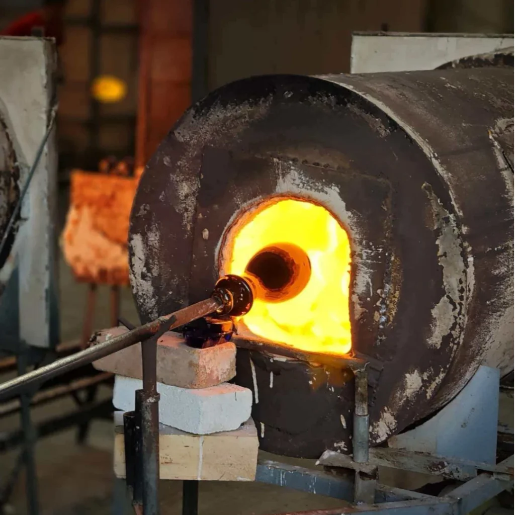 Skilled glassmaker shaping imperial yellow glass vase with hand tools, traditional Chinese glassmaking craft, by Heritage & Craft.