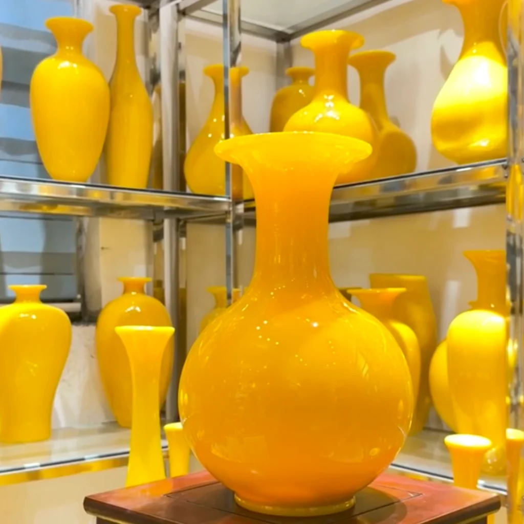 Finished chicken-fat yellow glass vase with hand-carved landscape design, warm imperial yellow hue and polished finish, by Heritage & Craft.