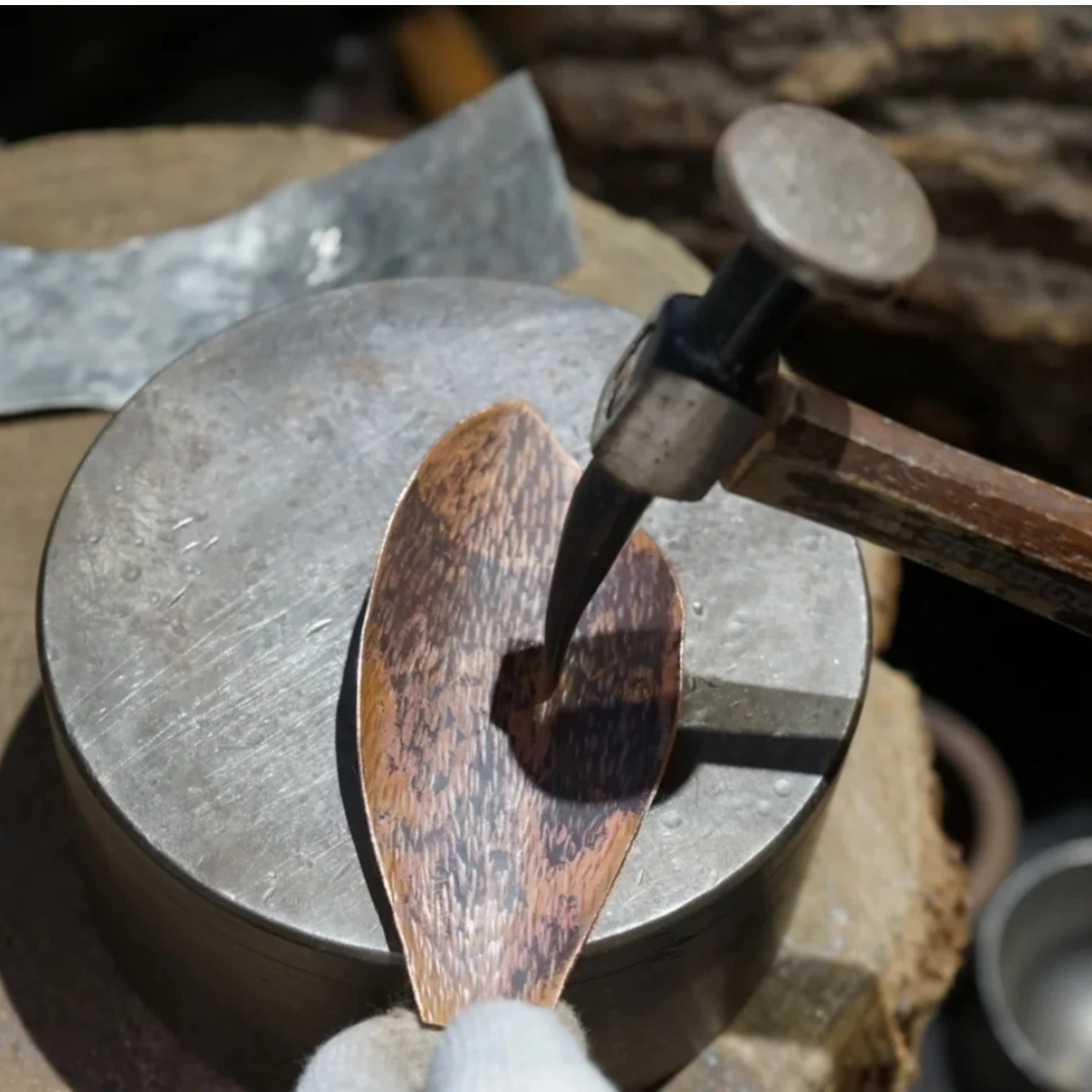 Close-up of hammered copper surface showing hand-hammered texture and dimpled metal finish, traditional Chinese metal craft, by Heritage & Craft.