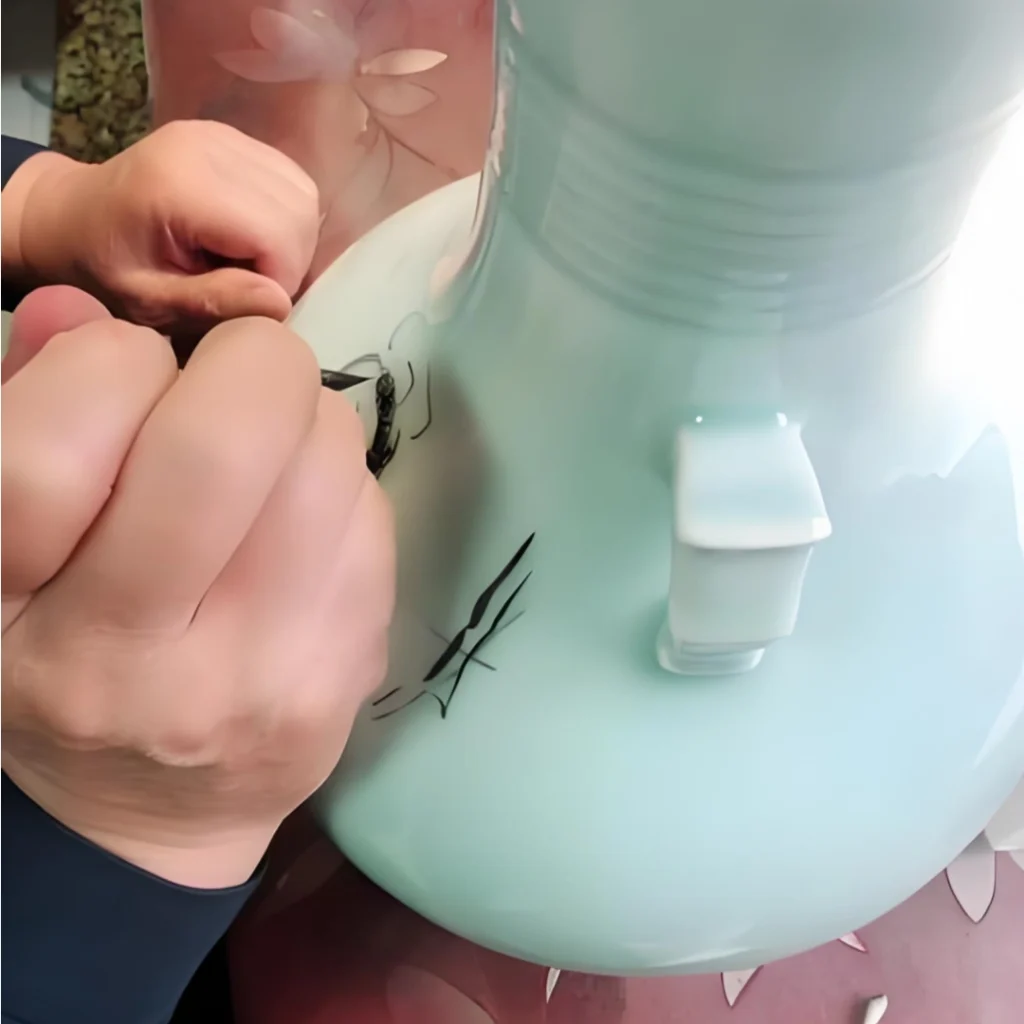 Artisan hand-painting landscape scenery on Luqing celadon porcelain, traditional ceramic decoration process, by Heritage & Craft.