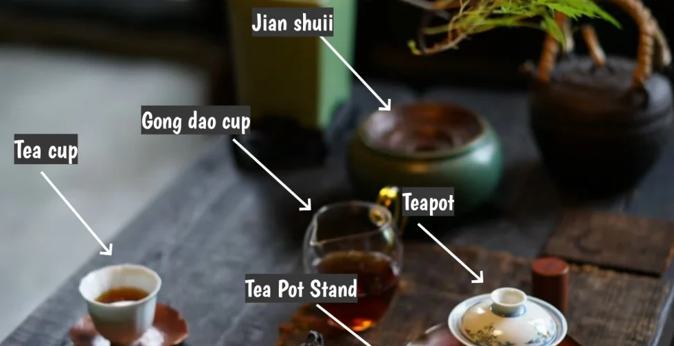 A complete Chinese gongfu tea set arranged on a tea tray, featuring a clay teapot and a porcelain gaiwan as brewing vessels, a glass fairness cup for even distribution, multiple small ceramic tasting cups, a hammered copper tea boat under the teapot, a hammered copper waste water bowl (jianshui) at the side, and hammered copper cup holders beneath each drinking cup, with bamboo tea tools neatly placed nearby — all set up for a traditional tea brewing session.